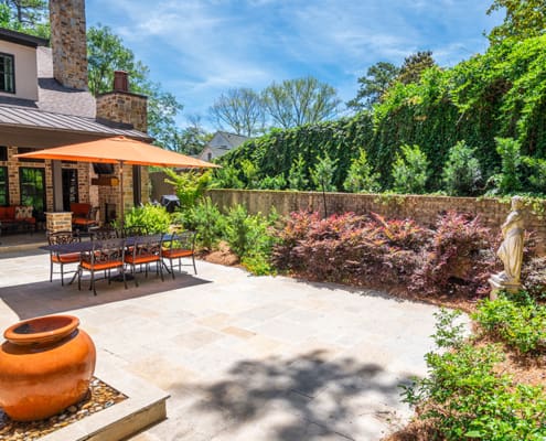 A beautiful lawn-free courtyard garden featuring luscious shrubs and a custom water feature. This landscape was designed and built by R&R Landscaping.