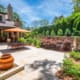 A beautiful lawn-free courtyard garden featuring luscious shrubs and a custom water feature. This landscape was designed and built by R&R Landscaping.