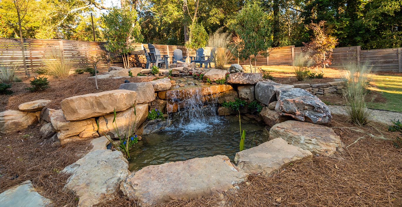 R&R Landscaping A peaceful backyard retreat that includes a water feature and fire pit sitting area. This outdoor living space was designed and built by R&R Landscaping.
