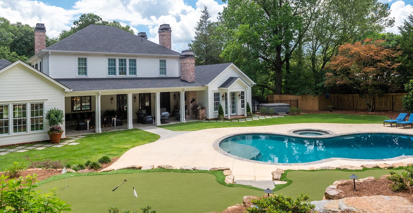 R&R Landscaping A resort-style backyard with beautiful plants, a swimming pool, fire pit, and putting green. This landscape was designed and built by R&R Landscaping.