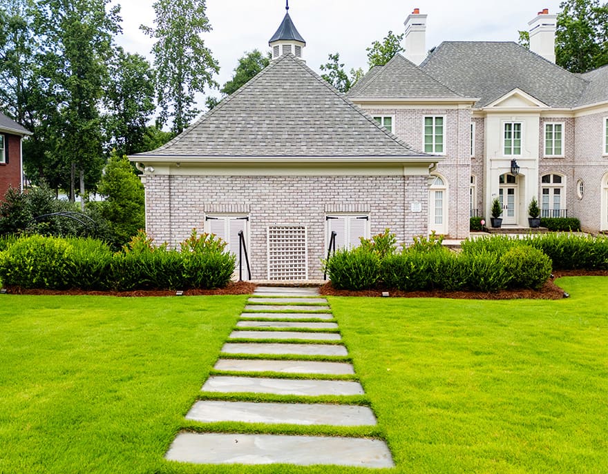 R&R Landscaping A beautiful outdoor living space designed and built by R&R Landscaping, complete with luscious plants and intentional stone paths to guide guests through the garden, all designed to be comforting and welcoming.