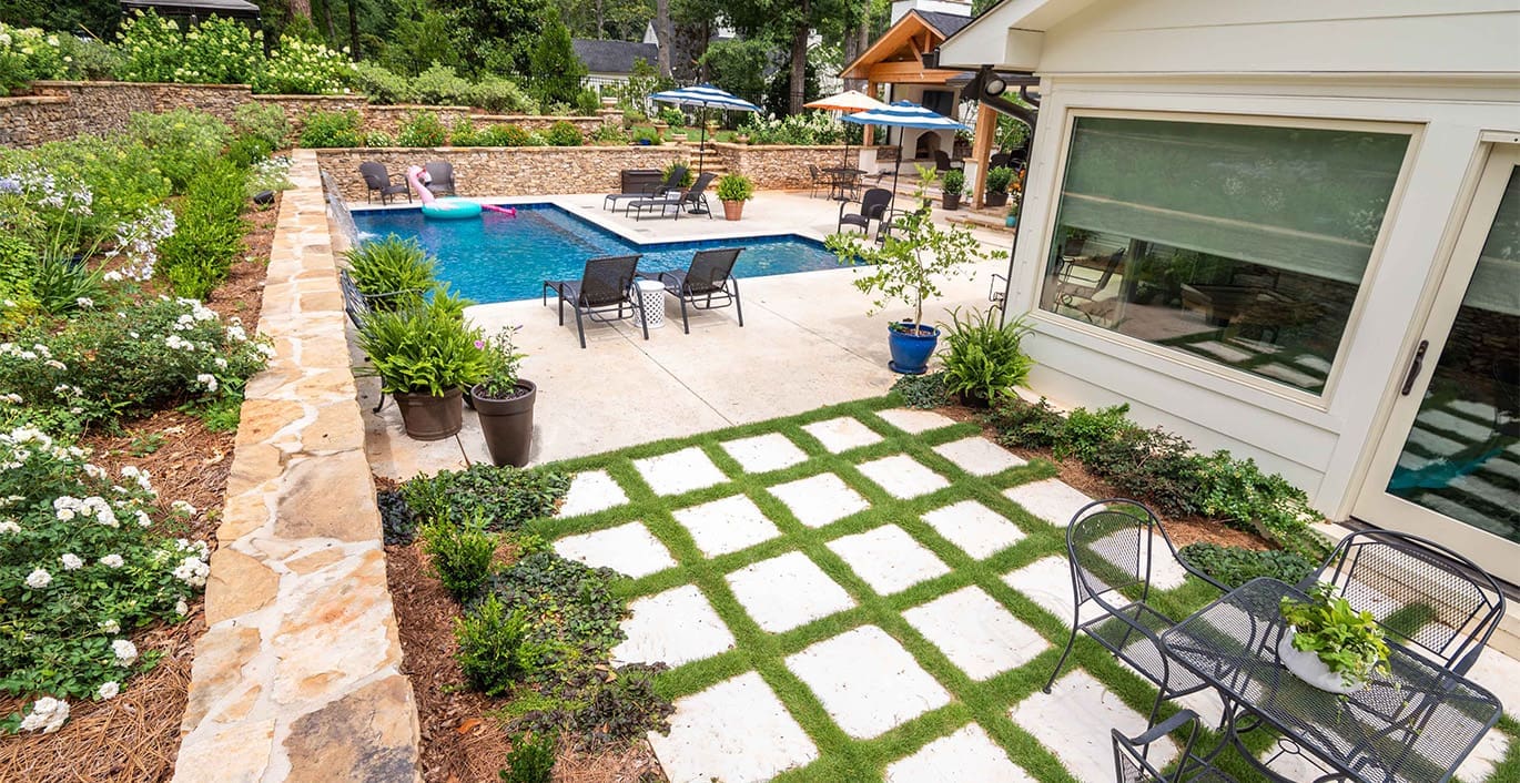 R&R Landscaping A beautiful resort-inspired landscape with unique drainage solutions, complete with layered plant walls, year-round seasonal color, and new sod for a landscape built to last. This project was designed and built by R&R Landscaping.