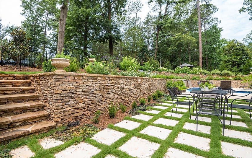 R&R Landscaping A beautiful resort-inspired landscape with unique drainage solutions, complete with layered plant walls, year-round seasonal color, and new sod for a landscape built to last. This project was designed and built by R&R Landscaping.