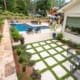 A beautiful resort-inspired landscape with unique drainage solutions, complete with layered plant walls, year-round seasonal color, and new sod for a landscape built to last. This project was designed and built by R&R Landscaping.